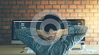 Asian programmers man are relaxing and looking at the code on the computer screen in the office Stock Photo