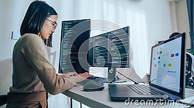 Asian prompt engineer develop coding app with software data sitting in front of computer monitor at office Stock Photo