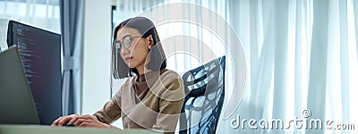Asian prompt engineer develop coding app with software data sitting in front of computer monitor at office Stock Photo