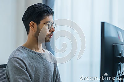 Asian prompt engineer developer coding app with software data sitting in front of computer monitor at office Stock Photo