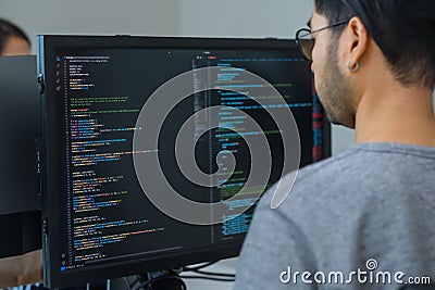 Asian promt engineer develope coding app with software data sitting in front of computer monitor at office Stock Photo