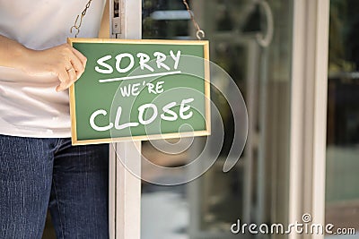 Asian restaurant owners are hanging a blackboard with the word closed Stock Photo