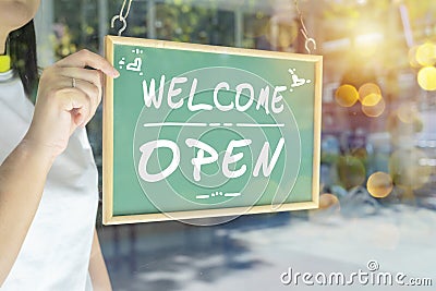 Asian restaurant owners are hanging a blackboard with the word welcome open to open the shop Stock Photo