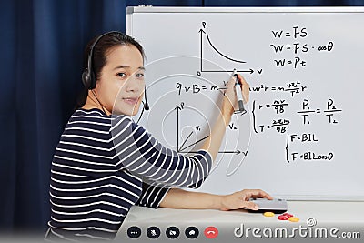 Asian school woman teacher working from home teach online math to student studying from home. Teacher writeing on whiteboard and Stock Photo