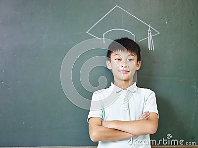 Asian schoolboy standing under a chalk-drawn doctoral cap Stock Photo