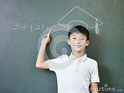 Asian schoolboy standing under a chalk-drawn doctoral hat Stock Photo