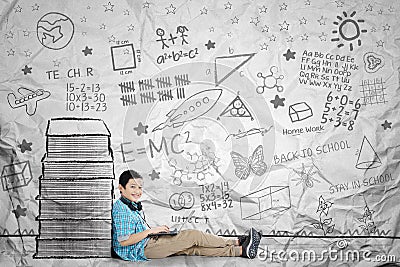 Asian schoolboy using a laptop near drawn books Stock Photo