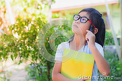 Asian schoolgirl holding books and pencils Stock Photo