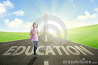 Asian schoolgirl standing above education word Stock Photo