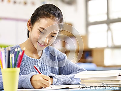 Asian schoolgirl studying in classroom Stock Photo