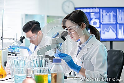 Asian scientist use microscope Stock Photo