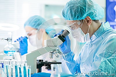 Asian scientist use microscope Stock Photo