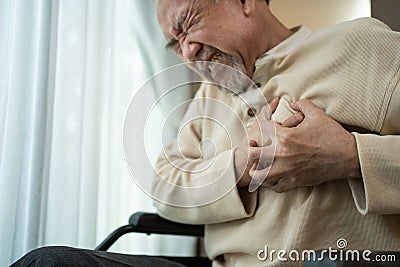 Asian Senior disabled male with chest pain suffer from heart attack. Elderly Older male on wheelchair has difficulty breath Stock Photo