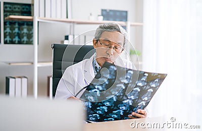 Asian Senior Doctor looking chest x-ray film in hospital. Stock Photo