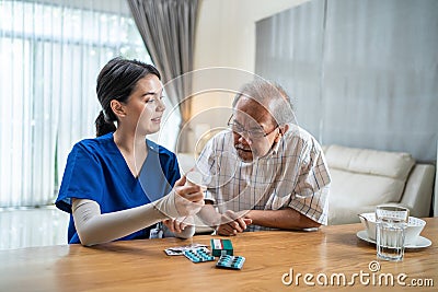 Asian Senior elderly male patient consult with physician nurse at nursing home care. Caregiver therapist pharmacist girl hold medi Stock Photo