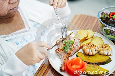 Asian senior or elderly old lady woman patient eating breakfast vegetable healthy food with hope and happy while sitting and Stock Photo