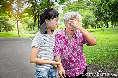 Asian senior grandmother has headache,touching her head with her hands,vertigo;dizziness;sick elderly moman having heat stroke, Stock Photo