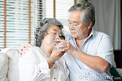 Asian Senior husband taking care his wife Stock Photo
