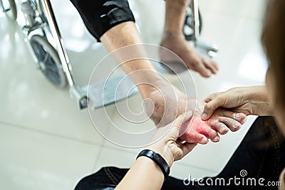 Asian senior mother in wheelchair,receiving a foot massage from her daughter,physiology pressing with fingers to relax,old woman Stock Photo
