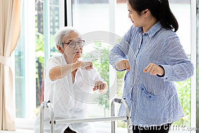 Asian senior people sitting relax with walker during rehabilitation and young carer,elderly woman or mother smiling and exercise Stock Photo