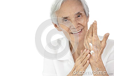 Asian senior woman applying baby lotion on hands,rubbing her palm with hands cream,moisturizer cream used to prevent dryness, Stock Photo