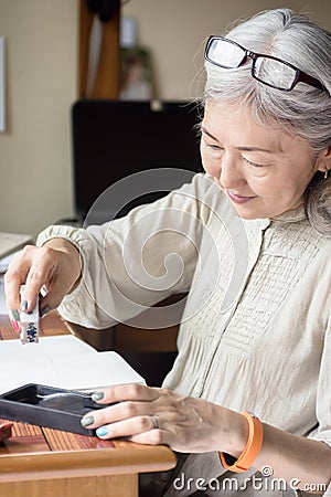 Asian senior woman artist using Suiteki and sudzuri Stock Photo