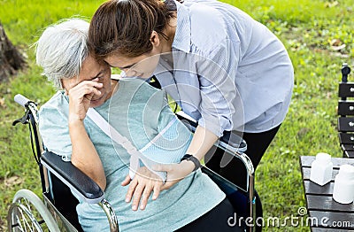 Asian senior woman crying suffering elbow arm fracture, broken bone,old people is injured in accident wearing arm sling after Stock Photo