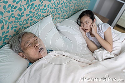 Asian senior woman snoring loudly open mouth comfortably sleeping danger of obstructive sleep apnea disease stressed child girl Stock Photo