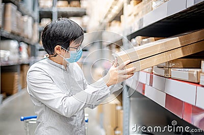 Asian shopper picking cardboard box in warehouse Stock Photo