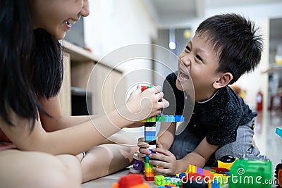 Asian sister is helping the parent to take care of her little brother and playing toys together at home,happy kid boy and child Stock Photo