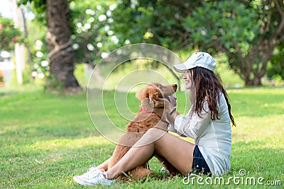 Asian smilling lifestyle woman playing and happy with golden retriever friendship dog in sunrise Stock Photo