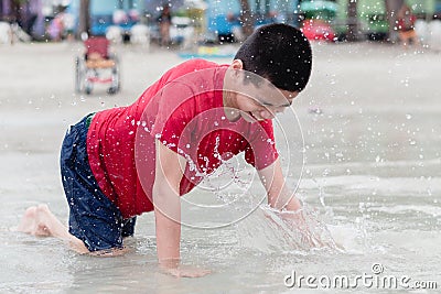 Asian special child playing sand and crawls happily on the beach Stock Photo