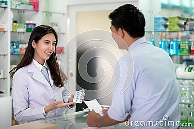 Asian Specialist girl explain about how to use a drug capsule in her drugstore Stock Photo