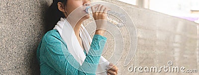 sporty woman drinking water to rehydrate after jogging exercise Stock Photo