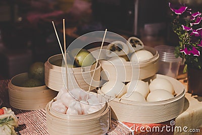 Asian steamed buns in bamboo steamers at street food market Stock Photo