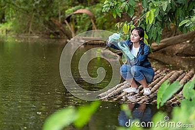 Asian student biology taking and testing sample of natural river water. Experts science women keep water for research analysis in Stock Photo