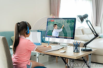 Asian student girl video conference e-learning with teacher on computer in living room at home. E-learning ,online ,education and Stock Photo