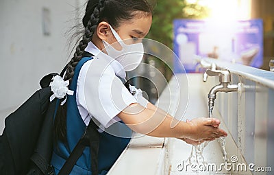 Asian student washing hands at the outdoor wash basin in the school. Preventing Contagious diseases, Plague. Kids health, Stock Photo
