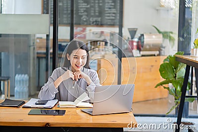 Asian students hang wireless headphones around their necks and write laptops to learn languages online. Watch and listen to laptop Stock Photo