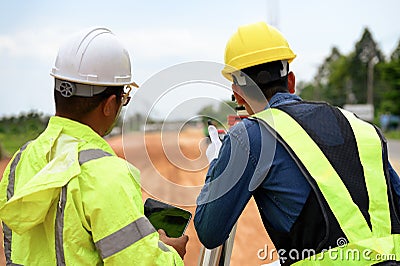 Asian surveyor engineer two people checking level of soil with Surveyor's Telescope equipment to measure leveling Stock Photo