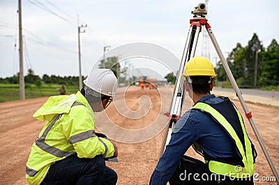 Asian surveyor engineer two people checking level of soil with Surveyor's Telescope equipment to measure leveling Stock Photo