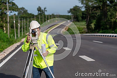 Asian surveyor engineer worker making measuring with theodolite on road works. survey engineer at road construction site, Surveyor Stock Photo