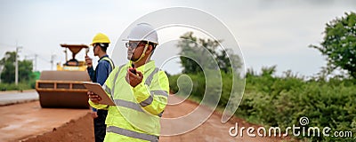 Asian surveyor engineers use tablet to check detail in job, Control schedule of work of highway road construction projects with Stock Photo