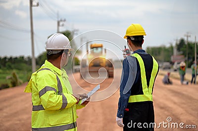 Asian surveyor engineers use tablet to check detail in job, Control schedule of work of highway road construction projects with Stock Photo