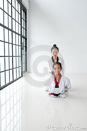 Asian Taekwondo teacher and student are action to get muscle relaxation by different posture before and after training Stock Photo