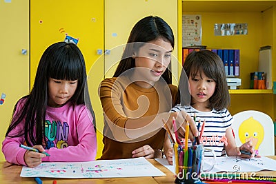 Asian teacher and preschool student in art class Stock Photo