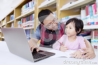 Asian teacher teaches female student in library Stock Photo