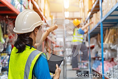 Asian teamwork of Foreman and female laborer working in a warehouse. Working Woman Concept Stock Photo