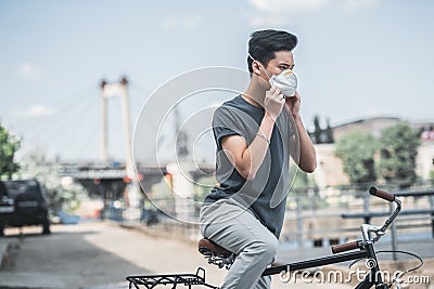 asian teen wearing protective mask with bicycle air Stock Photo