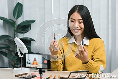 Asian teenage girls doing makeup vlogs and using a video mobile camera to record vlogs and publish them online at home Stock Photo